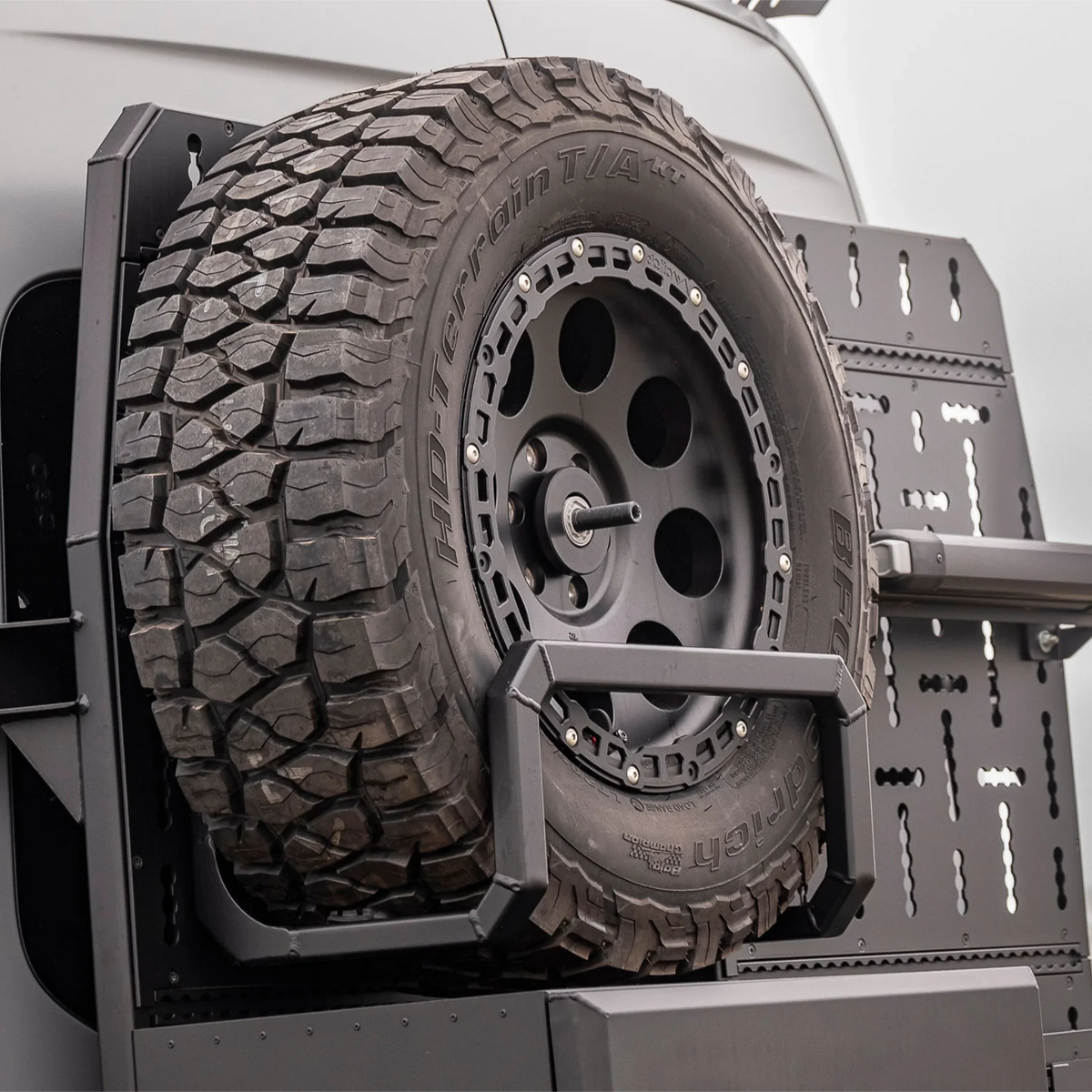 XBull spare wheel carrier holding an off-road tire on a Sprinter rear rack, view 10