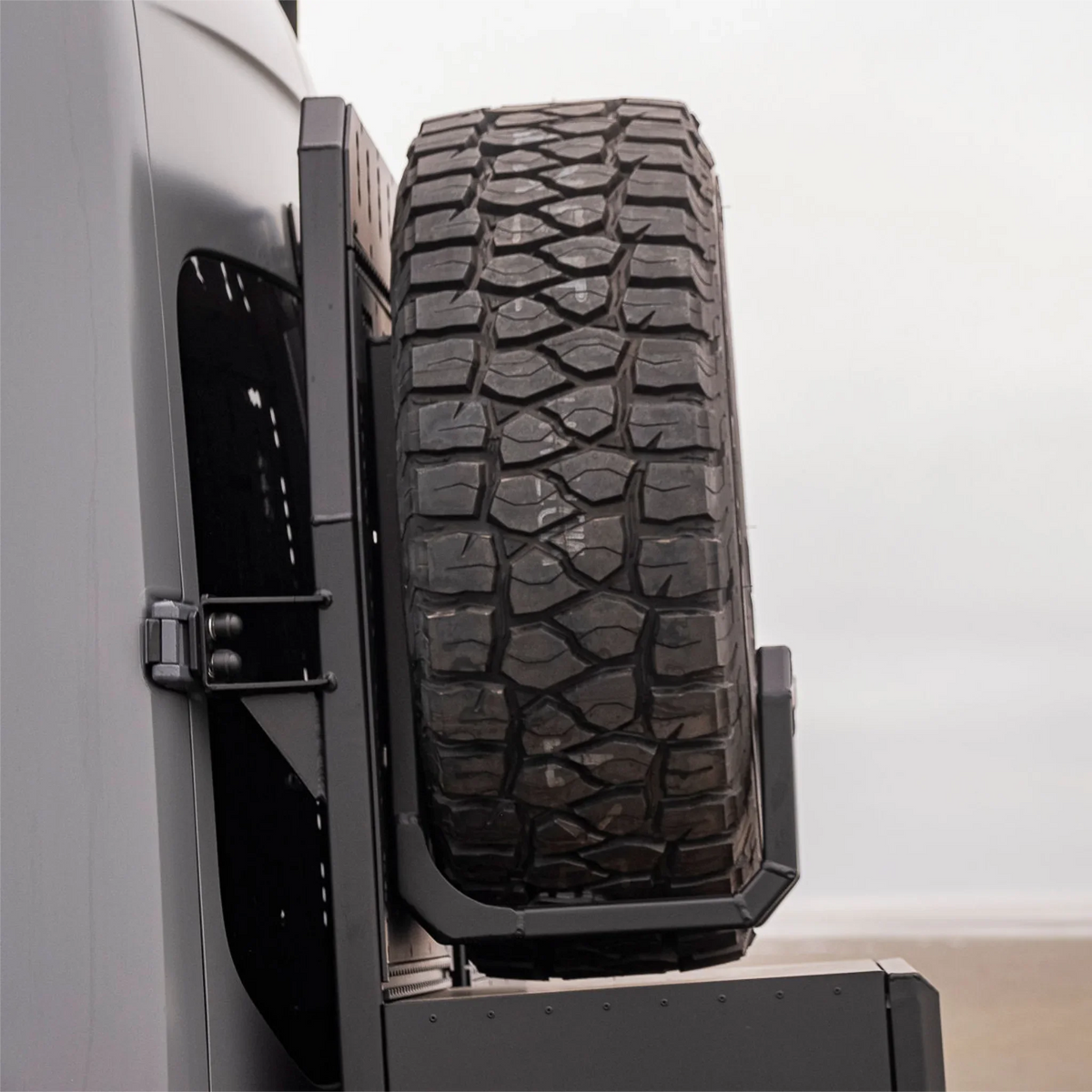 XBull spare wheel carrier holding an off-road tire on a Sprinter rear rack, view 6